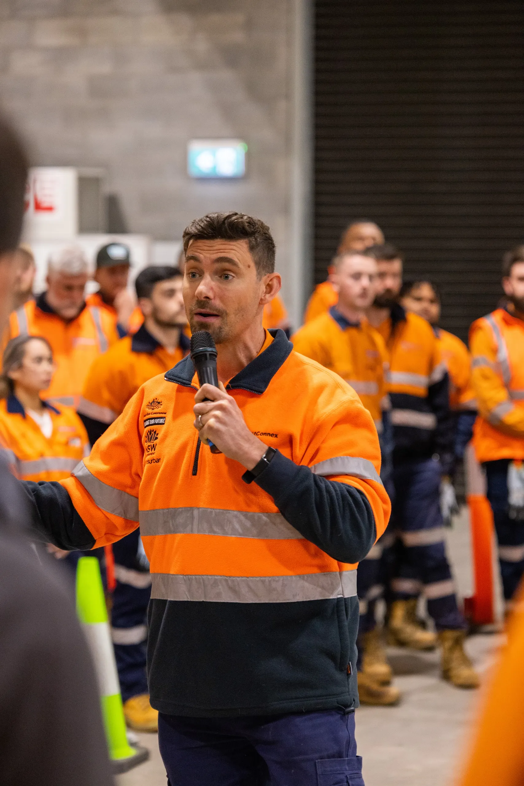 Jeremiah Hartmann, founder of Impact Communication Solutions, addressing a workforce briefing in high-vis