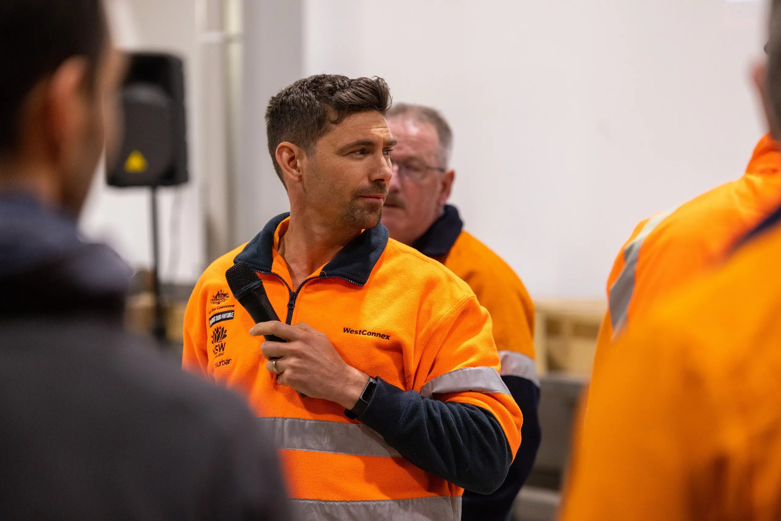 Jeremiah Hartmann in WestConnex high-vis gear preparing to address the workforce